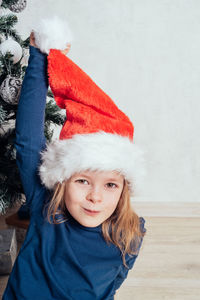 Portrait of cute baby girl sitting on bed at home