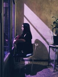 Woman sitting on chair at home