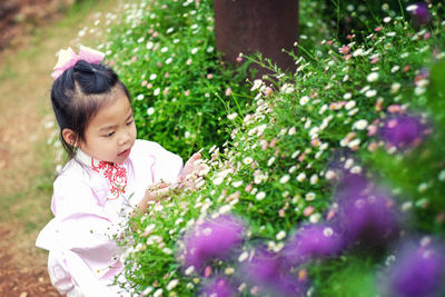 Cute girl looking at flowering plants