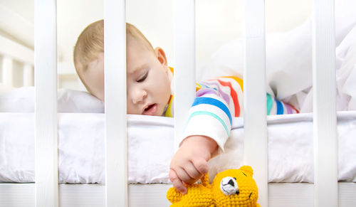 Portrait of cute baby boy playing with toy at home