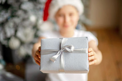 Midsection of girl holding gift box at home