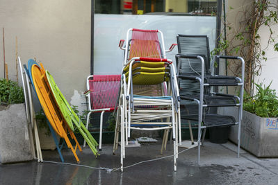 Empty chairs and tables at sidewalk cafe against building