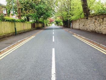 Empty road along trees