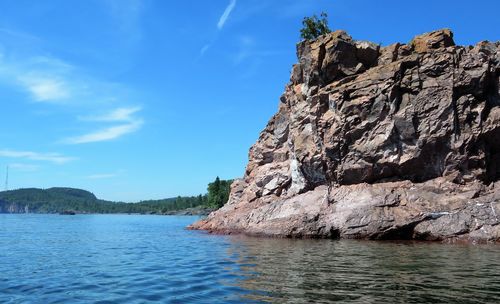 Rock formations by sea against sky