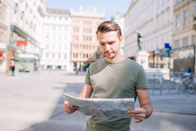 Portrait of young man using mobile phone in city