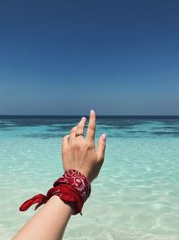 Midsection of hands against sea against sky