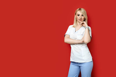 Portrait of a young woman against red background