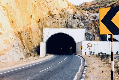 Road passing through tunnel on rocky mountain