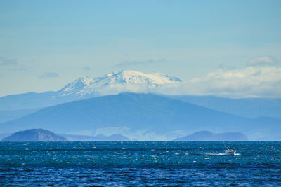 Scenic view of sea and mountains against sky