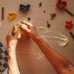 Cropped hands of woman kneading dough on table