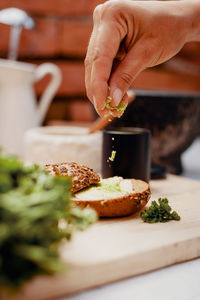 Cropped hand of person preparing food on table