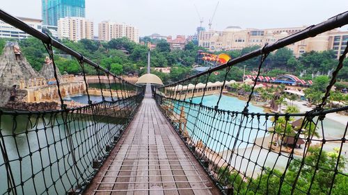 Narrow footbridge along trees