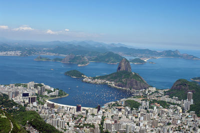 High angle view of townscape by sea against sky