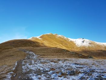 Scenic view of snowcapped mountains against clear blue sky