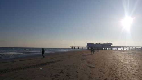 Silhouette man on beach against clear sky during sunset