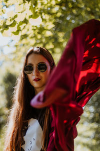 Portrait of young woman wearing sunglasses standing outdoors