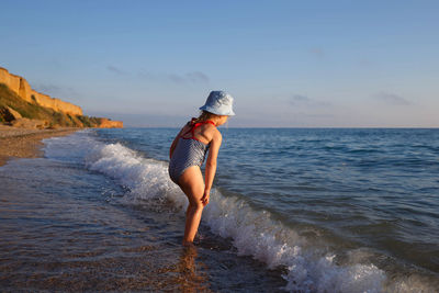 Full length of girl on beach against sky