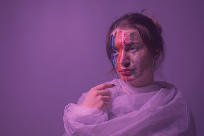 Portrait of young woman against pink background