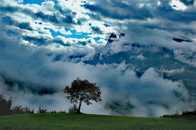 Scenic view of grassy field against cloudy sky