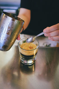 Close-up of hand pouring drink in glass
