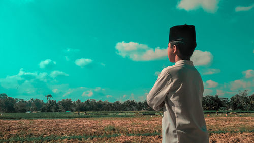 Man standing on field against sky