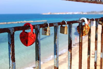 Close-up of padlocks on railing against sea