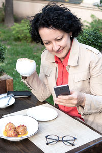 Young man using phone on table