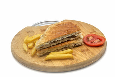 Close-up of breakfast served on cutting board against white background