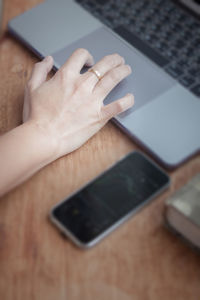 Midsection of person using smart phone on table