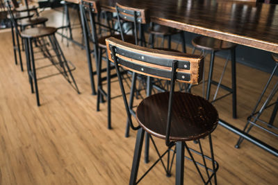 Empty chairs on hardwood floor in cafe