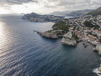 High angle view of townscape by sea against sky