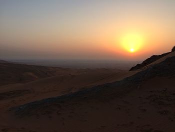 Scenic view of desert against sky during sunset