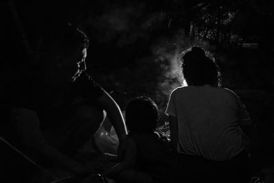 Rear view of couple sitting on stage at night