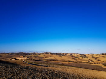 Scenic view of desert against clear blue sky