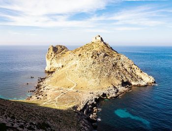 Rock formation on beach against sky
