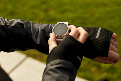 A close up of a woman's hand interacting with her fitness watch.