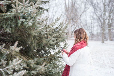 Woman walking on snow covered tree