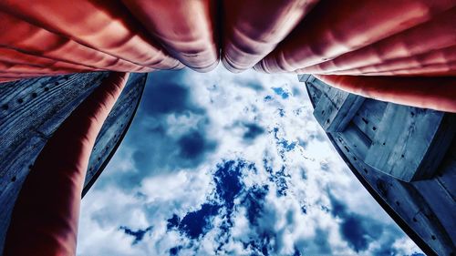 Low angle view of human hand against sky