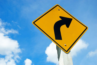 Low angle view of road sign against sky