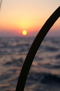 Close-up of silhouette plant against sea during sunset