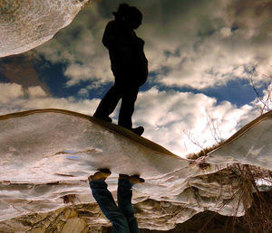 Low section of woman with reflection in puddle