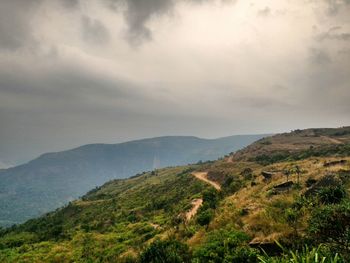 Scenic view of mountains against cloudy sky
