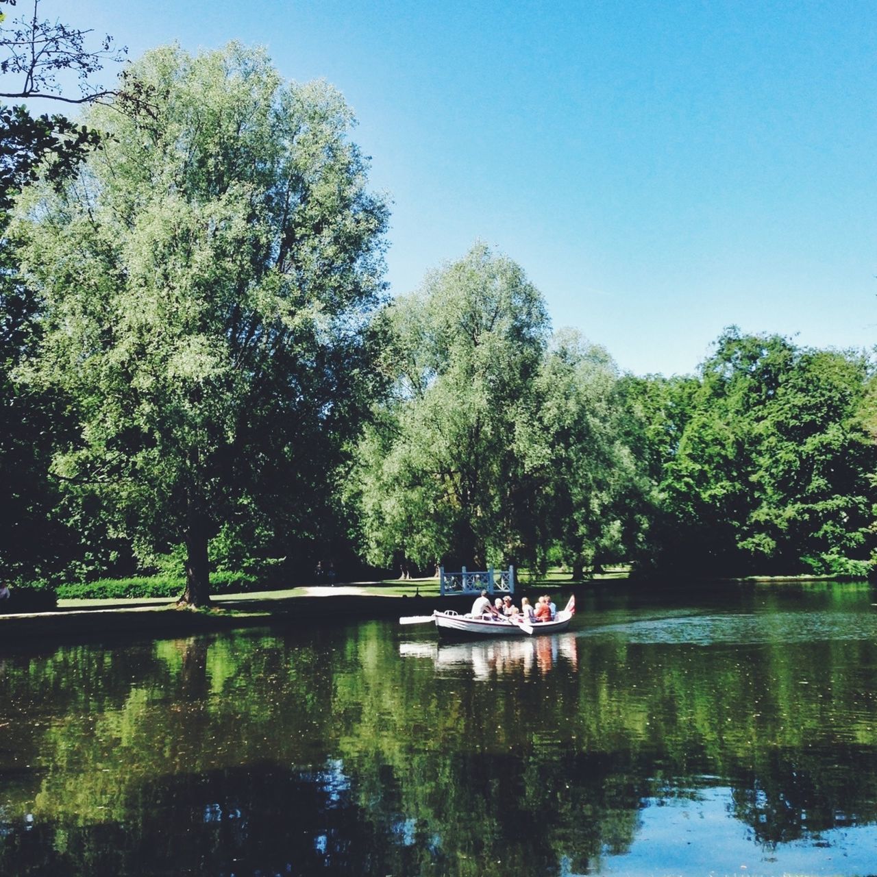 tree, water, men, clear sky, lake, leisure activity, nautical vessel, transportation, lifestyles, person, mode of transport, waterfront, reflection, boat, tranquility, river, nature, tranquil scene, growth