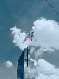 Low angle view of flag by building against sky