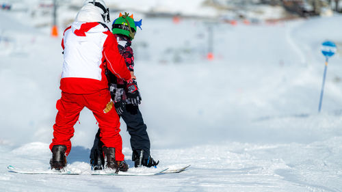 Boy learning snowboarding with an instructor