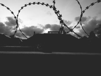 Low angle view of barbed wire fence against sky