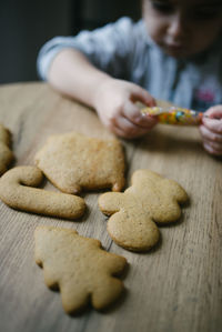 Midsection of woman holding cookies on table