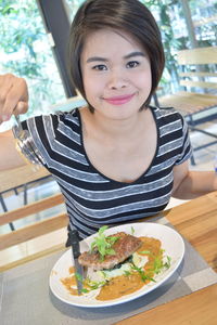 Portrait of woman having food in restaurant