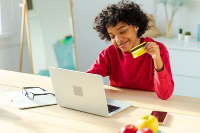 Young woman using laptop at table