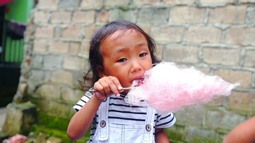 Portrait of cute girl holding face outdoors